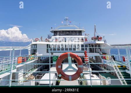 Croatie, baie de Kvarner, côte Adriatique, ferry de Lopar (île de Rab) à Valbiska (île de Krk), vue depuis le ferry avec les voitures garées et les passagers sur le pont Banque D'Images