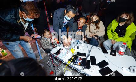 220905 -- LUDING, 5 septembre 2022 -- les gens chargent leurs téléphones portables dans un point de service China Telecom dans un abri temporaire dans la ville de Moxi, dans le comté de Luding, dans le sud-ouest de la Chine, province du Sichuan, le 5 septembre 2022. Quarante-six personnes ont été tuées dans un tremblement de terre de magnitude 6,8 qui a secoué lundi le comté de Luding, dans la province du Sichuan, dans le sud-ouest de la Chine, ont déclaré les autorités locales lors d un point de presse. CHINE-SICHUAN-ABRI SISMIQUE CN ShenxBohan PUBLICATIONxNOTxINxCHN Banque D'Images