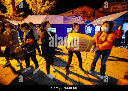 220905 -- LUDING, 5 septembre 2022 -- des personnes passent des fournitures de secours dans un abri temporaire dans la ville de Moxi, dans le comté de Luding, dans le sud-ouest de la Chine, province du Sichuan, le 5 septembre 2022. Quarante-six personnes ont été tuées dans un tremblement de terre de magnitude 6,8 qui a secoué lundi le comté de Luding, dans la province du Sichuan, dans le sud-ouest de la Chine, ont déclaré les autorités locales lors d un point de presse. CHINE-SICHUAN-ABRI SISMIQUE CN ShenxBohan PUBLICATIONxNOTxINxCHN Banque D'Images