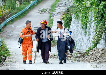 220906 -- MOXI, 6 septembre 2022 -- des sauveteurs accompagnent un résident affecté par le séisme évacué de la ville de Detuo, dans le comté de Luding, dans la province du Sichuan du sud-ouest de la Chine, le 6 septembre 2022. Un total de 66 personnes ont été tuées dans un tremblement de terre de magnitude 6,8 qui a secoué lundi le comté de Luding, dans la province du Sichuan, dans le sud-ouest de la Chine, ont déclaré mardi les autorités locales. Mardi 2 heures, 38 personnes avaient été tuées dans la préfecture autonome tibétaine de Ganzi, et les 28 autres sont mortes dans la ville de ya an, a déclaré le quartier général des secours lors d'un point de presse. CHINE-SICHUAN-SECOURS AUX VICTIMES DU TREMBLEMENT DE TERRE CN SHENXBOHAN PUBLICATIONXNOTXIN Banque D'Images