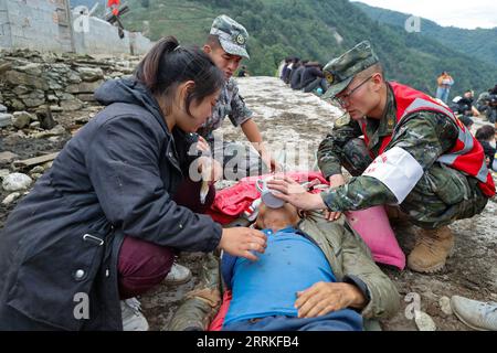 220906 -- MOXI, le 6 septembre 2022 -- des sauveteurs alimentent en eau un résident blessé évacué de la ville de Detuo, dans le comté de Luding, dans la province du Sichuan du sud-ouest de la Chine, le 6 septembre 2022. Un total de 66 personnes ont été tuées dans un tremblement de terre de magnitude 6,8 qui a secoué lundi le comté de Luding, dans la province du Sichuan, dans le sud-ouest de la Chine, ont déclaré mardi les autorités locales. Mardi 2 heures, 38 personnes avaient été tuées dans la préfecture autonome tibétaine de Ganzi, et les 28 autres sont mortes dans la ville de ya an, a déclaré le quartier général des secours lors d'un point de presse. CHINE-SICHUAN-SECOURS AUX VICTIMES DU TREMBLEMENT DE TERRE CN SHENXBOHAN PUBLICATIONXNOTXINX Banque D'Images