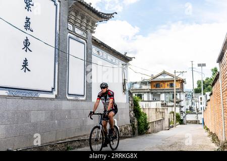 220908 -- DALI, 8 septembre 2022 -- Jos Van der Wiel fait du vélo dans un village de Dali, province du Yunnan au sud-ouest de la Chine, 29 août 2022. Cela fait plus de 40 ans que Jos Van der Wiel est arrivé en Chine depuis les pays-Bas. Au fil des décennies, le Néerlandais a grandi en aimant organiser les touristes du monde entier pour voyager autour de la Chine à vélo. Au cours de ses tours à vélo, Jos a appris à bien connaître la Chine. Il a même compilé un guide de voyage en Chine, offrant un guide complet aux lecteurs néerlandais. En 2000, alors que Jos explorait de nouvelles routes pour des excursions à vélo dans la province du Yunnan du sud-ouest de la Chine, il rencontra son épouse actuelle Huang J. Banque D'Images