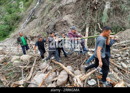 Chine, Erdbeben in Sichuan, Bergungsarbeiten 220908 -- MOXI, 8 septembre 2022 -- des gens emmènent une personne blessée évacuée du village de Mozigou près de la ville de Moxi, dans le comté de Luding, dans le sud-ouest de la Chine, province du Sichuan, le 8 septembre 2022. Au total, 86 personnes ont été tuées et 35 sont toujours portées disparues après un tremblement de terre de magnitude 6,8 qui a secoué le comté de Luding dans la province du Sichuan lundi, ont déclaré jeudi les autorités locales. CHINE-SICHUAN-LUDING-TREMBLEMENT DE TERRE-SAUVETAGE CN SHENXBOHAN PUBLICATIONXNOTXINXCHN Banque D'Images