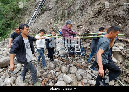 Chine, Erdbeben in Sichuan, Bergungsarbeiten 220908 -- MOXI, 8 septembre 2022 -- des gens emmènent une personne blessée évacuée du village de Mozigou près de la ville de Moxi, dans le comté de Luding, dans le sud-ouest de la Chine, province du Sichuan, le 8 septembre 2022. Au total, 86 personnes ont été tuées et 35 sont toujours portées disparues après un tremblement de terre de magnitude 6,8 qui a secoué le comté de Luding dans la province du Sichuan lundi, ont déclaré jeudi les autorités locales. CHINE-SICHUAN-LUDING-TREMBLEMENT DE TERRE-SAUVETAGE CN SHENXBOHAN PUBLICATIONXNOTXINXCHN Banque D'Images