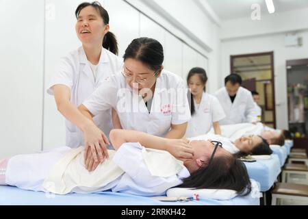 220909 -- BEIJING, 9 septembre 2022 -- Zhang Lin R, front enseigne à un étudiant malvoyant les techniques de massage à l'Université de Beijing Union à Beijing, capitale de la Chine, le 8 septembre 2022. Zhang a enseigné Tuina , massage thérapeutique chinois, aux étudiants malvoyants depuis qu'elle a obtenu son diplôme de l'Université de médecine chinoise de Pékin en 1995. La plupart de ses étudiants ont commencé leur carrière dans des professions relatives. CHINE-PÉKIN-ÉDUCATION SPÉCIALE CN JuxHuanzong PUBLICATIONxNOTxINxCHN Banque D'Images