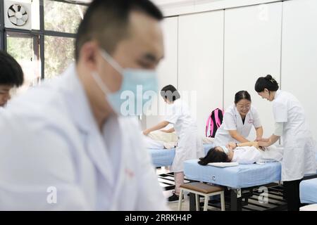 220909 -- BEIJING, 9 septembre 2022 -- Zhang Lin 2nd R enseigne les techniques de massage à un étudiant malvoyant à l'Université de Beijing Union à Beijing, capitale de la Chine, le 8 septembre 2022. Zhang a enseigné Tuina , massage thérapeutique chinois, aux étudiants malvoyants depuis qu'elle a obtenu son diplôme de l'Université de médecine chinoise de Pékin en 1995. La plupart de ses étudiants ont commencé leur carrière dans des professions relatives. CHINE-PÉKIN-ÉDUCATION SPÉCIALE CN JuxHuanzong PUBLICATIONxNOTxINxCHN Banque D'Images