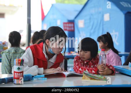 220909 -- ya AN, 9 septembre 2022 -- Un volontaire raconte des histoires à un enfant dans un refuge de secours contre le tremblement de terre dans le comté de Shimian, dans la ville de ya an, dans le sud-ouest de la Chine, province du Sichuan, le 9 septembre 2022. CHINE-SICHUAN-YA AN-TREMBLEMENT DE TERRE-RELIEF CN LIUXQIONG PUBLICATIONXNOTXINXCHN Banque D'Images