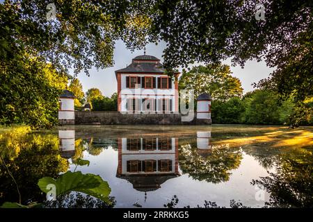 Le château à douves ou Wasserburg près de Seligenstadt, beau parc du château avec lac au coucher du soleil Banque D'Images