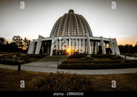 Temple BA 'í à Hofheim im Taunus. Belle église ou lieu de culte au lever du soleil. Un bâtiment moderne en dôme dans un paysage avec de la lavande au premier plan. Allemagne Banque D'Images