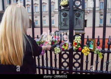 Londres, Royaume-Uni. 08 septembre 2023. Une femme dépose des fleurs devant le palais de Buckingham à l'occasion du premier anniversaire de la mort de la reine Elizabeth II Crédit : SOPA Images Limited/Alamy Live News Banque D'Images