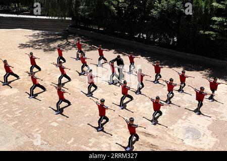 220929 -- ZHENGZHOU, 29 septembre 2022 -- Li Yinggang en noir enseigne aux élèves lors d'un cours d'arts martiaux à l'école d'arts martiaux Shaolin Tagou à Songshan, province du Henan, dans le centre de la Chine, le 7 juillet 2022. Li Yinggang, 25 ans, est entraîneur à l'école d'arts martiaux Shaolin Tagou à Songshan, dans la province du Henan, au centre de la Chine. Il a commencé à pratiquer les arts martiaux à l'âge de 9 ans et est passé au combat libre 3 ans plus tard. Depuis qu'il a 16 ans, Li a participé aux compétitions professionnelles de combat libre, remportant les titres d'événements nationaux et internationaux à plusieurs reprises, dont deux gol Banque D'Images