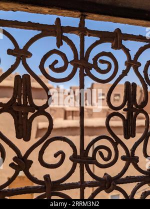 Grille de fenêtre traditionnelle ornée d'une maison berbère en ruine dans le centre-ville d'Amezrou, Maroc Banque D'Images