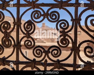 Grille de fenêtre traditionnelle ornée d'une maison berbère en ruine dans le centre-ville d'Amezrou, Maroc Banque D'Images