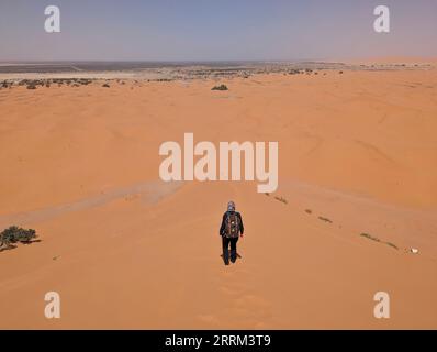 Randonnée dans la grande dune de Merzouga dans le désert d'Erg Chebbi, Sahara marocain Banque D'Images