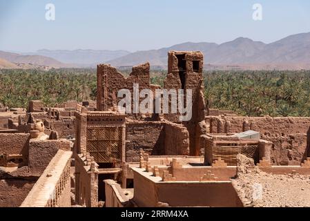 Vue sur les toits du village de Tamenougalt avec ses maisons en argile typiques, la vallée du Draa en arrière-plan, au Maroc Banque D'Images