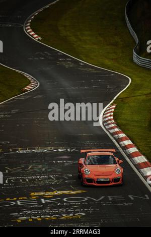 Porsche orange sur la Nürburgring Nordschleife Banque D'Images