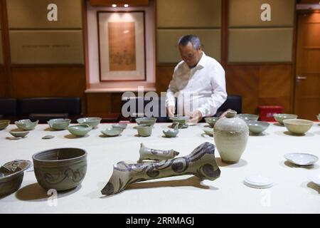 221011 -- WENZHOU, 11 octobre 2022 -- Un chercheur vérifie les céramiques découvertes sur le site archéologique de l'ancien port de Shuomen à Wenzhou, dans la province du Zhejiang de l'est de la Chine, le 11 octobre 2022. Le site archéologique de l'ancien port de Shuomen a été découvert à la fin de 2021, avec des ruines de bâtiments anciens, des épaves et des pièces de porcelaine mises au jour dans les fouilles archéologiques suivantes. Selon l'Administration nationale du patrimoine culturel, la découverte est importante pour les études de l'ancienne route maritime de la soie. CHINE-ZHEJIANG-WENZHOU-SHUOMEN ANCIEN PORT-RUINES CN WENGXXINYANG PUBLIC Banque D'Images