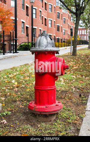 Bouche d'incendie de style américain rouge traditionnel à dessus argenté à l'extérieur d'un immeuble de logements modernes sur College Street, Burlington, Vermont Banque D'Images