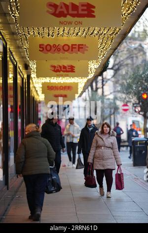 221214 -- MANCHESTER, 14 déc. 2022 -- des gens passent devant des panneaux promotionnels à Manchester, Grande-Bretagne, 13 déc. 2022. La flambée de l’inflation a forcé de nombreux ménages à réévaluer leurs dépenses pour Noël cette année. Photo de /Xinhua BRITAIN-MANCHESTER-CHRISTMAS-INFLATION JonxSuper PUBLICATIONxNOTxINxCHN Banque D'Images