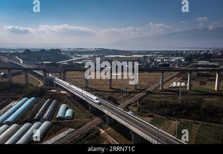 221216 -- KUNMING, 16 décembre 2022 -- cette photo aérienne prise le 16 décembre 2022 montre un train circulant sur le centre du chemin de fer à grande vitesse Mile-Mengzi qui croise deux autres chemins de fer supérieurs et inférieurs dans la préfecture autonome de Honghe Hani et Yi, dans le sud-ouest de la Chine, province du Yunnan. Un chemin de fer à grande vitesse, reliant les villes de Mengzi et Mile dans la province du Yunnan au sud-ouest de la Chine, est entré en service vendredi. Avec une vitesse prévue de 250 km/h, le nouveau chemin de fer a réduit le temps de trajet entre Mengzi et Kunming, la capitale provinciale, à 69 minutes. CHINE-YUNNAN-MILE-MENGZI HAUTE VITESSE R Banque D'Images