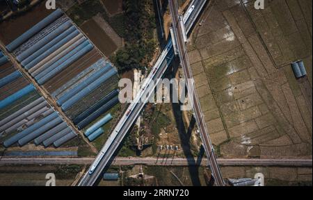 221216 -- KUNMING, 16 décembre 2022 -- cette photo aérienne prise le 16 décembre 2022 montre un train circulant sur le centre du chemin de fer à grande vitesse Mile-Mengzi qui croise deux autres chemins de fer supérieurs et inférieurs dans la préfecture autonome de Honghe Hani et Yi, dans le sud-ouest de la Chine, province du Yunnan. Un chemin de fer à grande vitesse, reliant les villes de Mengzi et Mile dans la province du Yunnan au sud-ouest de la Chine, est entré en service vendredi. Avec une vitesse prévue de 250 km/h, le nouveau chemin de fer a réduit le temps de trajet entre Mengzi et Kunming, la capitale provinciale, à 69 minutes. CHINE-YUNNAN-MILE-MENGZI HAUTE VITESSE R Banque D'Images