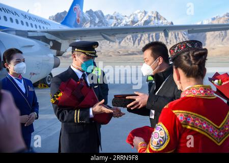 221223 -- TAXKORGAN, le 23 décembre 2022 -- l'équipage du premier vol reçoit un bouquet de fleurs et un chapeau ethnique tadjik à l'aéroport de Taxkorgan, dans le comté autonome tadjik de Taxkorgan, dans la région autonome ouïgour du Xinjiang, au nord-ouest de la Chine, le 23 décembre 2022. Vendredi matin, un avion de passagers est arrivé dans le comté autonome tadjik de Taxkorgan, dans la région autonome ouïgoure du Xinjiang, au nord-ouest de la Chine, marquant l inauguration du premier aéroport de haut plateau de la région. Au départ de la capitale régionale Urumqi à 8:57 heures du matin, le vol CZ5193, opéré par China Southern Airlines, a atterri à l'aéroport a de Taxkorgan Banque D'Images