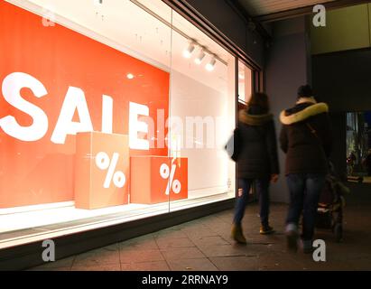 221231 -- BERLIN, le 31 décembre 2022 -- des gens passent devant une vitrine de magasin avec des panneaux de rabais à Berlin, Allemagne, le 30 décembre 2022. ALLEMAGNE-BERLIN-VIE QUOTIDIENNE RenxPengfei PUBLICATIONxNOTxINxCHN Banque D'Images