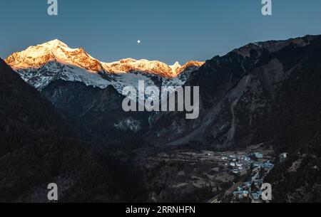 230114 -- DEQEN, 14 janvier 2023 -- cette photo aérienne prise dans le village de Yubeng, dans le comté de Deqen, dans la province du Yunnan, au sud-ouest de la Chine, montre la lumière du soleil qui brille sur la montagne enneigée de Meili le 9 janvier 2023. Wangden, 34 ans, est directrice associée de la branche Yunnan de la centrale électrique Yanmen de China Southern Power Grid dans le comté de Deqen. En 2015, il a été chargé des tâches d'entretien à Yubeng, un village local situé au pied de montagnes enneigées. En tant que travailleur de Yubeng ayant servi le plus longtemps dans l'approvisionnement en électricité, l'homme a été témoin de changements considérables dans le village. Dans le passé, Yubeng était virtuellement Banque D'Images