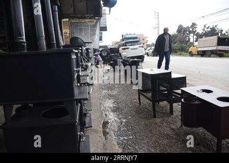 230117 -- AKKAR LIBAN, 17 janvier 2023 -- Un homme passe devant un magasin vendant des poêles à bois dans le gouvernorat d'Akkar, au nord du Liban, le 17 janvier 2023. Le leader du Hezbollah a accusé mardi les États-Unis d'empêcher le Liban de prendre gratuitement du carburant en Iran alors même que son pays souffre de pannes de courant. Le Liban souffre depuis des décennies de coupures de courant. Son effondrement économique depuis 2019 a pesé sur le trésor de l État, ralentissant les importations de carburant pour maintenir le fonctionnement des centrales restantes. Photo de /Xinhua LEBANON-AKKAR-FUEL-SPARY KhaledxHabashiti PUBLICATIONxNOTxINxCHN Banque D'Images