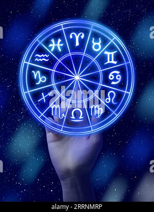 Astrologie. Femme touchant la roue du zodiaque sur fond lumineux, gros plan Banque D'Images