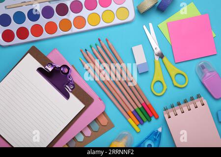 Composition de pose plate avec presse-papiers et autre papeterie scolaire sur fond bleu clair. Retour à l'école Banque D'Images