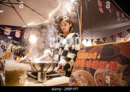 230211 -- CHONGQING, le 11 février 2023 -- Un vendeur cuisine lors d'une foire nocturne dans le district de Nan an, dans la municipalité de Chongqing au sud-ouest de la Chine, le 9 février 2023. Depuis le début de l'année, Chongqing a lancé diverses activités nocturnes pour stimuler l'économie nocturne. CHINE-CHONGQING-ÉCONOMIE DE NUIT CN HuangxWei PUBLICATIONxNOTxINxCHN Banque D'Images