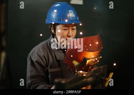 230308 -- HARBIN, 8 mars 2023 -- le soudeur Zhang Jinghua travaille chez China Railway Rolling stock Corporation CRRC Qiqihar Rolling stock Co., Ltd à Qiqihar, dans la province du Heilongjiang du nord-est de la Chine, le 6 mars 2023. Les entreprises de la province du Heilongjiang, une ancienne base industrielle du nord-est de la Chine, ont progressé vers l'objectif de prendre un bon départ au premier trimestre de 2023. Il y a beaucoup de travailleuses qui jouent un rôle actif dans divers lieux de travail. La Journée internationale de la femme, célébrée mercredi, est une excellente occasion de rendre hommage à la She Power . Photo de /Xinhua CHINA-HEILON Banque D'Images