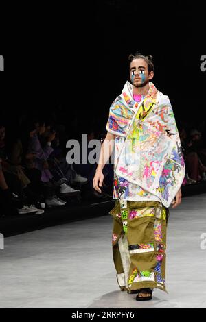 230322 -- TEL AVIV, le 22 mars 2023 -- Un mannequin présente une création faite de vêtements d'occasion et de matériaux rejetés lors de la Fashion week de tel Aviv à tel Aviv, Israël, le 19 mars 2023. Chiffons, canettes, film plastique délavé... Les vêtements transformés en déchets ménagers ont fait des débuts accrocheurs sur le podium de la Fashion week de tel Aviv en Israël, avec l événement de cette année mettant en lumière la mode durable. La semaine annuelle de la mode s’est terminée mercredi, mais la discussion sur la mode durable est loin d’être terminée. Ici, dans le centre économique et high-tech d'Israël, la mode va au-delà de la beauté et de la délicatesse, comme organi Banque D'Images