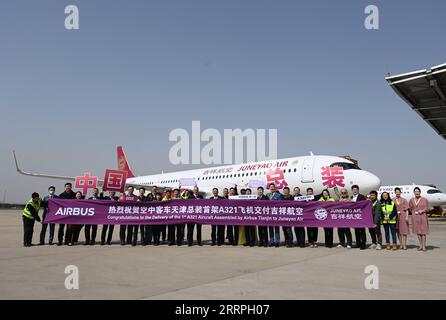 230324 -- TIANJIN, le 24 mars 2023 -- des membres du personnel de l'avionneur européen Airbus et de Juneyao Air, basé à Shanghai, qui assistent à la cérémonie de livraison du premier avion A321neo assemblé en Chine, posent pour une photo de groupe devant l'avion à Tianjin, dans le nord de la Chine, le 24 mars 2023. Le constructeur aéronautique européen Airbus a commencé vendredi à livrer des avions A321neo assemblés sur son site FALA de la chaîne d'assemblage final Asia, dans le nord de la Chine, à Tianjin. Le premier avion A321neo assemblé en Chine a été livré à Juneyao Air, basé à Shanghai. Airbus a commencé à produire des avions de la série A321 au Banque D'Images