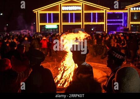 230329 -- Akto, le 29 mars 2023 -- des villageois et des touristes assistent à une fête de feu de joie dans le village de Bahrigzi, dans le canton de Tar Tajik, dans le comté d'Akto, dans la région autonome ouïgoure du Xinjiang, au nord-ouest de la Chine, le 27 mars 2023. Tar Tajik Township, niché dans l'arrière-pays des montagnes Kunlun, est un village touristique rural national clé dans le comté d'Akto, dans le nord-ouest de la Chine de la région autonome ouïgour du Xinjiang. Comme le temps se réchauffe, les fleurs d'abricot sont en pleine floraison ici. Le magnifique paysage naturel et les coutumes folkloriques uniques attirent de nombreux touristes. Ces dernières années, le gouvernement local a accéléré la construction Banque D'Images