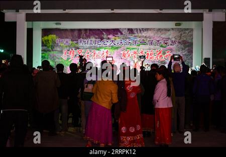 230329 -- Akto, le 29 mars 2023 -- des touristes et des villageois assistent à une représentation dans le village de Bahrigzi, dans le canton de Tar Tajik, comté d'Akto, région autonome ouïgoure du Xinjiang, au nord-ouest de la Chine, le 28 mars 2023. Tar Tajik Township, niché dans l'arrière-pays des montagnes Kunlun, est un village touristique rural national clé dans le comté d'Akto, dans le nord-ouest de la Chine de la région autonome ouïgour du Xinjiang. Comme le temps se réchauffe, les fleurs d'abricot sont en pleine floraison ici. Le magnifique paysage naturel et les coutumes folkloriques uniques attirent de nombreux touristes. Ces dernières années, le gouvernement local a accéléré la construction Banque D'Images