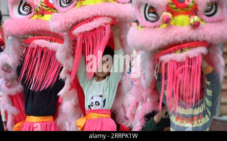 230329 -- WUZHOU, le 29 mars 2023 -- des enfants pratiquent la danse du lion dans une école maternelle du comté de Tengxian de Wuzhou, dans la région autonome de Guangxi Zhuang, dans le sud de la Chine, le 28 mars 2023. La danse du lion Tengxian, inscrite au patrimoine culturel immatériel national, est une combinaison d'arts martiaux, de danse, de musique et d'acrobaties. Ces dernières années, le comté de Tengxian a activement intégré la danse du lion dans les cours dans les jardins d'enfants et les écoles, dans le but de transmettre cette forme d'art traditionnel aux jeunes générations. CHINE-GUANGXI-WUZHOU-LION DANSE-ÉDUCATION CN HUANGXXIAOBANG PUBLICATIONXN Banque D'Images