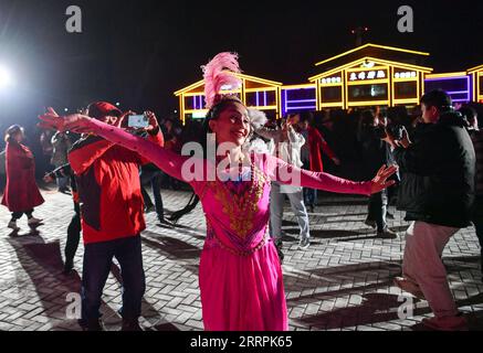 230329 -- Akto, le 29 mars 2023 -- des villageois dansent en costumes traditionnels dans le village de Bahrigzi, dans le canton de Tar Tajik, comté d'Akto, région autonome ouïgoure du Xinjiang, au nord-ouest de la Chine, le 27 mars 2023. Tar Tajik Township, niché dans l'arrière-pays des montagnes Kunlun, est un village touristique rural national clé dans le comté d'Akto, dans le nord-ouest de la Chine de la région autonome ouïgour du Xinjiang. Comme le temps se réchauffe, les fleurs d'abricot sont en pleine floraison ici. Le magnifique paysage naturel et les coutumes folkloriques uniques attirent de nombreux touristes. Ces dernières années, le gouvernement local a accéléré la construction de Banque D'Images
