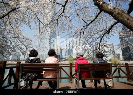 230330 -- SÉOUL, le 30 mars 2023 -- les touristes voient des cerisiers en fleurs au parc du lac Seokchon à Séoul, Corée du Sud, le 30 mars 2023. CORÉE DU SUD-SÉOUL-FLEURS DE CERISIER WangxYiliang PUBLICATIONxNOTxINxCHN Banque D'Images