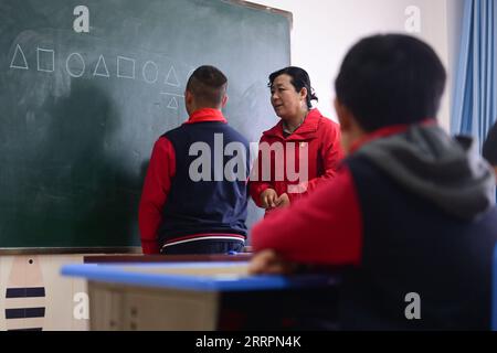 230402 -- XINING, le 2 avril 2023 -- Chen Zhifang C présente une formation cognitive pour un enfant autiste au centre de services spéciaux pour enfants Starlight à Xining, dans la province du Qinghai du nord-ouest de la Chine, le 30 mars 2023. Chen Zhifang est le fondateur du Starlight Special Children Service Center à Xining. Fondé en 2015, le centre de services est un organisme de bien-être public à but non lucratif qui offre une formation et une intervention en réadaptation précoce aux enfants atteints d'autisme, de déficience intellectuelle et de troubles du langage. Actuellement, 132 enfants autistes reçoivent diverses formations de réadaptation ici. O Banque D'Images