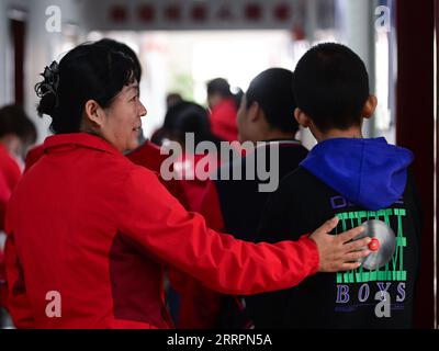 230402 -- XINING, le 2 avril 2023 -- Chen Zhifang L et des enfants autistes déjeunent au centre de services spéciaux pour enfants Starlight à Xining, dans la province du Qinghai, au nord-ouest de la Chine, le 30 mars 2023. Chen Zhifang est le fondateur du Starlight Special Children Service Center à Xining. Fondé en 2015, le centre de services est un organisme de bien-être public à but non lucratif qui offre une formation et une intervention en réadaptation précoce aux enfants atteints d'autisme, de déficience intellectuelle et de troubles du langage. Actuellement, 132 enfants autistes reçoivent diverses formations de réadaptation ici. Par le passé eig Banque D'Images