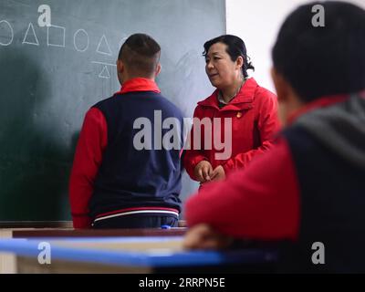 230402 -- XINING, le 2 avril 2023 -- Chen Zhifang C présente une formation cognitive pour un enfant autiste au centre de services spéciaux pour enfants Starlight à Xining, dans la province du Qinghai du nord-ouest de la Chine, le 30 mars 2023. Chen Zhifang est le fondateur du Starlight Special Children Service Center à Xining. Fondé en 2015, le centre de services est un organisme de bien-être public à but non lucratif qui offre une formation et une intervention en réadaptation précoce aux enfants atteints d'autisme, de déficience intellectuelle et de troubles du langage. Actuellement, 132 enfants autistes reçoivent diverses formations de réadaptation ici. O Banque D'Images