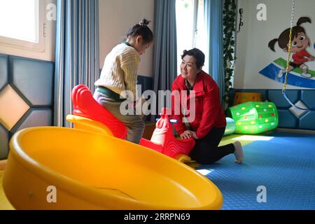 230402 -- XINING, le 2 avril 2023 -- Chen Zhifang R présente un entraînement physique pour un enfant autiste au centre de services spéciaux pour enfants Starlight à Xining, dans la province du Qinghai, au nord-ouest de la Chine, le 30 mars 2023. Chen Zhifang est le fondateur du Starlight Special Children Service Center à Xining. Fondé en 2015, le centre de services est un organisme de bien-être public à but non lucratif qui offre une formation et une intervention en réadaptation précoce aux enfants atteints d'autisme, de déficience intellectuelle et de troubles du langage. Actuellement, 132 enfants autistes reçoivent diverses formations de réadaptation ici. OV Banque D'Images