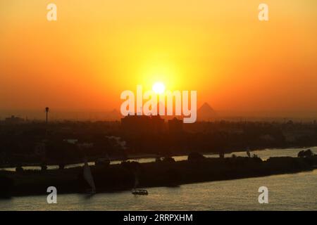 230416 -- LE CAIRE, le 16 avril 2023 -- cette photo prise le 15 avril 2023 montre les pyramides de Gizeh au coucher du soleil vues du Caire, en Égypte. EGYPTE-CAIRE-PYRAMIDES DE GIZEH-COUCHER DE SOLEIL DuanxMinfu PUBLICATIONxNOTxINxCHN Banque D'Images