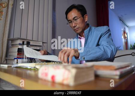 230422 -- LANZHOU, 22 avril 2023 -- Zhu Yanjun trie ses notes de poèmes chez lui dans le comté de Jingning, dans la province du Gansu du nord-ouest de la Chine, le 10 avril 2023. Zhu Yanjun, 50 ans, est finaliste du Concours de poésie chinoise 2023. Après avoir obtenu son diplôme du collège en 1992, il a arrêté ses études et a quitté sa ville natale, un village du comté de Jingning, dans la province du Gansu, au nord-ouest de la Chine, et a commencé à travailler comme travailleur migrant. Au cours des 30 dernières années, bien qu'il ait toujours été occupé à travailler pendant la journée, il a continué à passer son temps libre à poursuivre sa passion pour la poésie. Cette année, il enfin Banque D'Images