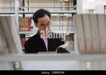 230422 -- LANZHOU, 22 avril 2023 -- Zhu Yanjun regarde un livre dans la bibliothèque du comté de Jingning, province du Gansu, au nord-ouest de la Chine, le 10 avril 2023. Zhu Yanjun, 50 ans, est finaliste du Concours de poésie chinoise 2023. Après avoir obtenu son diplôme du collège en 1992, il a arrêté ses études et a quitté sa ville natale, un village du comté de Jingning, dans la province du Gansu, au nord-ouest de la Chine, et a commencé à travailler comme travailleur migrant. Au cours des 30 dernières années, bien qu'il ait toujours été occupé à travailler pendant la journée, il a continué à passer son temps libre à poursuivre sa passion pour la poésie. Cette année, il enfin Banque D'Images