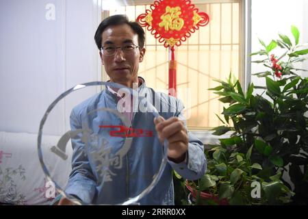 230422 -- LANZHOU, le 22 avril 2023 -- Zhu Yanjun montre la médaille de finaliste qu'il a remportée au Concours de poésie chinoise 2023 à domicile dans le comté de Jingning, dans la province du Gansu du nord-ouest de la Chine, le 10 avril 2023. Zhu Yanjun, 50 ans, est finaliste du Concours de poésie chinoise 2023. Après avoir obtenu son diplôme du collège en 1992, il a arrêté ses études et a quitté sa ville natale, un village du comté de Jingning, dans la province du Gansu, au nord-ouest de la Chine, et a commencé à travailler comme travailleur migrant. Au cours des 30 dernières années, bien qu'il ait toujours été occupé à travailler pendant la journée, il a continué à passer son temps libre à poursuivre salut Banque D'Images