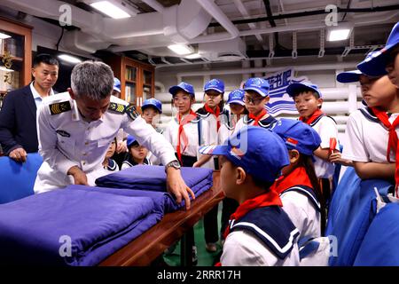 230424 -- QINGDAO, le 24 avril 2023 -- Un soldat de la marine PLA de l Armée populaire de libération chinoise fait une démonstration de pliage de courtepointe pour les étudiants en visite lors d une journée portes ouvertes dans un port militaire de Ningde, dans la province du Fujian du sud-est de la Chine, le 22 avril 2023. La marine de l'APL a organisé une gamme d'activités portes ouvertes à travers le pays pour souligner son 74e anniversaire de fondation qui est tombé dimanche. Au total, 62 casernes de la marine de l'APL dans 22 villes, dont Qingdao, Dalian, Shanghai et Guangzhou, sont ouvertes au public depuis vendredi. POUR ALLER AVEC China Focus : anniversaire de fondation de la marine de PLA commémoré Banque D'Images