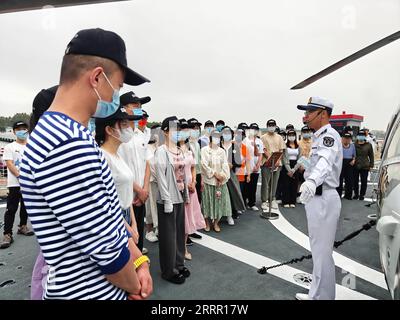 230424 -- QINGDAO, le 24 avril 2023 -- Un soldat de l Armée populaire de libération chinoise PLA Navy guide les visiteurs pour une visite à bord d un navire militaire lors d une journée portes ouvertes dans un port militaire à Zhanjiang, dans la province du Guangdong, dans le sud de la Chine, le 22 avril 2023. La marine de l'APL a organisé une gamme d'activités portes ouvertes à travers le pays pour souligner son 74e anniversaire de fondation qui est tombé dimanche. Au total, 62 casernes de la marine de l'APL dans 22 villes, dont Qingdao, Dalian, Shanghai et Guangzhou, sont ouvertes au public depuis vendredi. POUR ALLER AVEC China Focus : commémoration de l anniversaire de fondation de la marine de PLA Banque D'Images